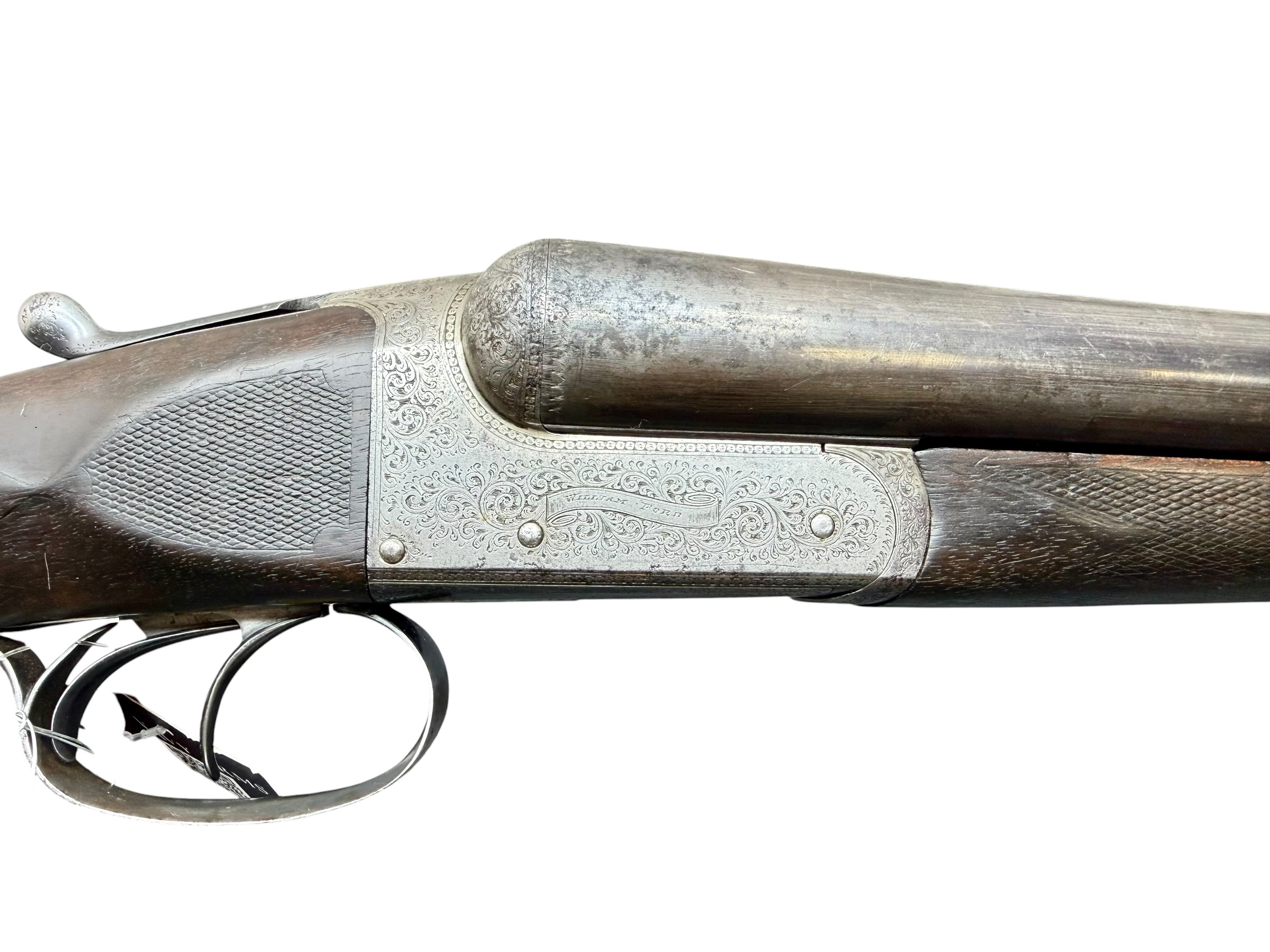 IMG_5308-Photoroom - OWS-Ammo Close-up of an antique, engraved pistol showing silver metalwork and a dark wooden grip.