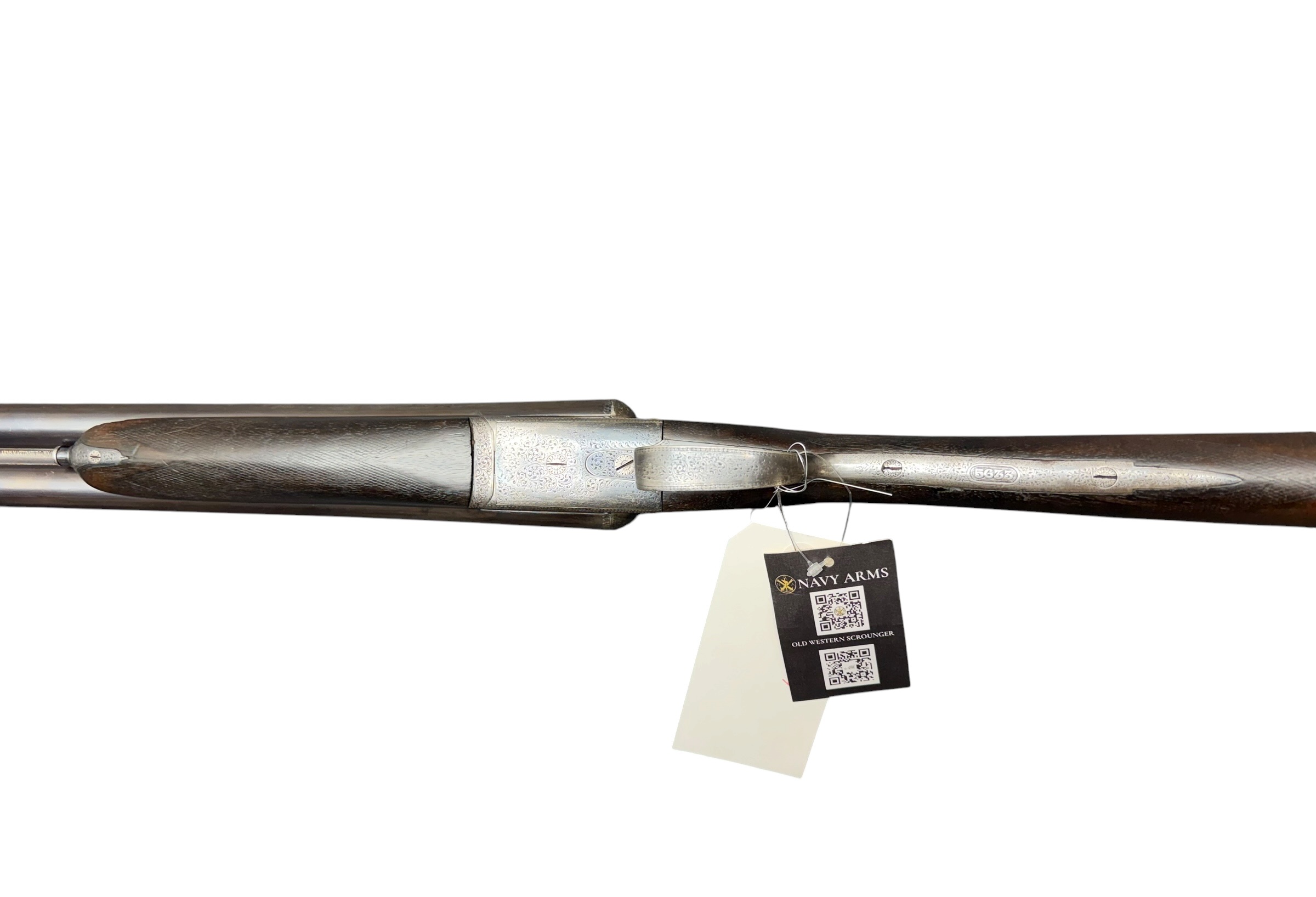 IMG_5319-Photoroom - OWS-Ammo Side view of an ornate antique shotgun with engraved metalwork and a hanging sale tag on the stock.