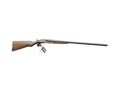 Rusty, long-barreled shotgun lying on its side with a wooden stock and metal barrel
